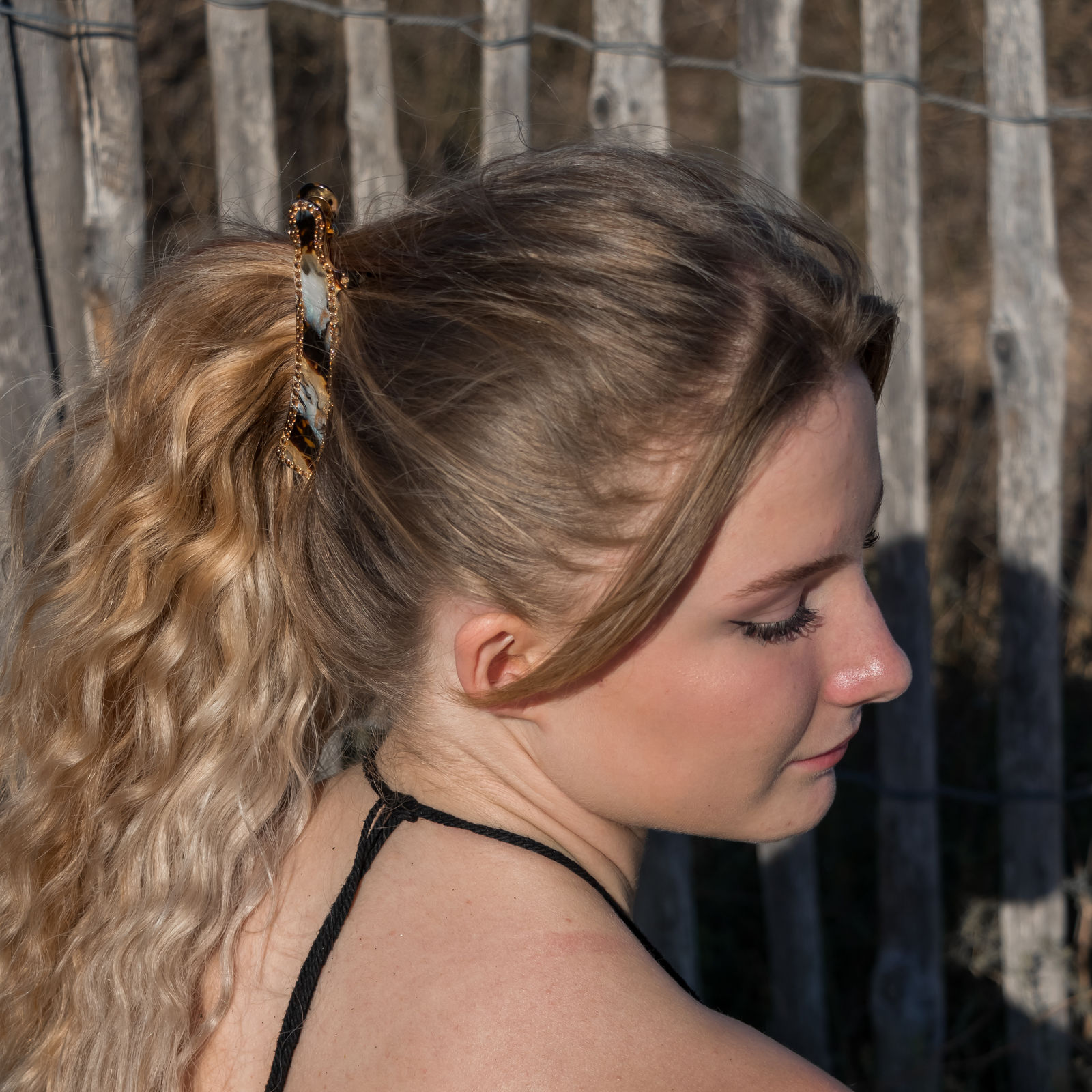 High wavy ponytail with a tortoiseshell clip, trendy hairstyle